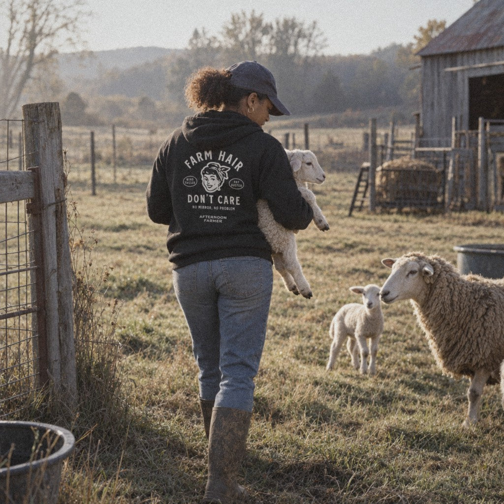 Farm Hair, Don't Care Hoodie in Black, picking up a lamb