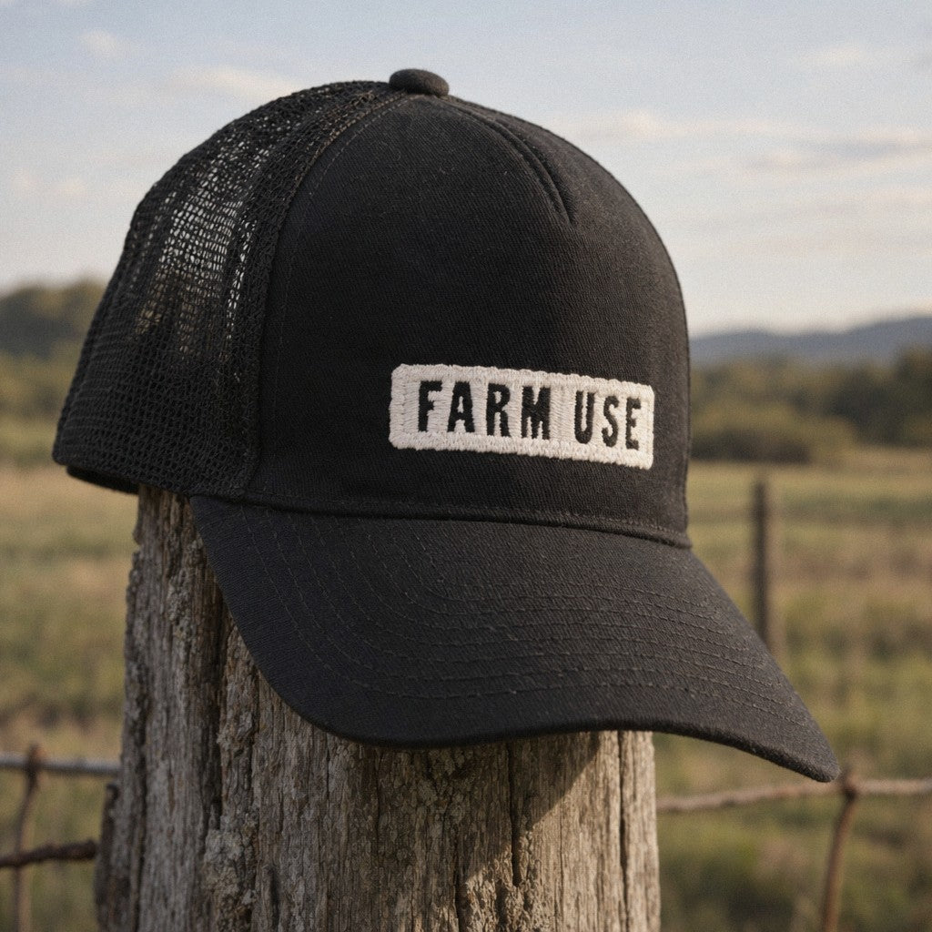 Farm Use Trucker Hat in Black, close-up hanging